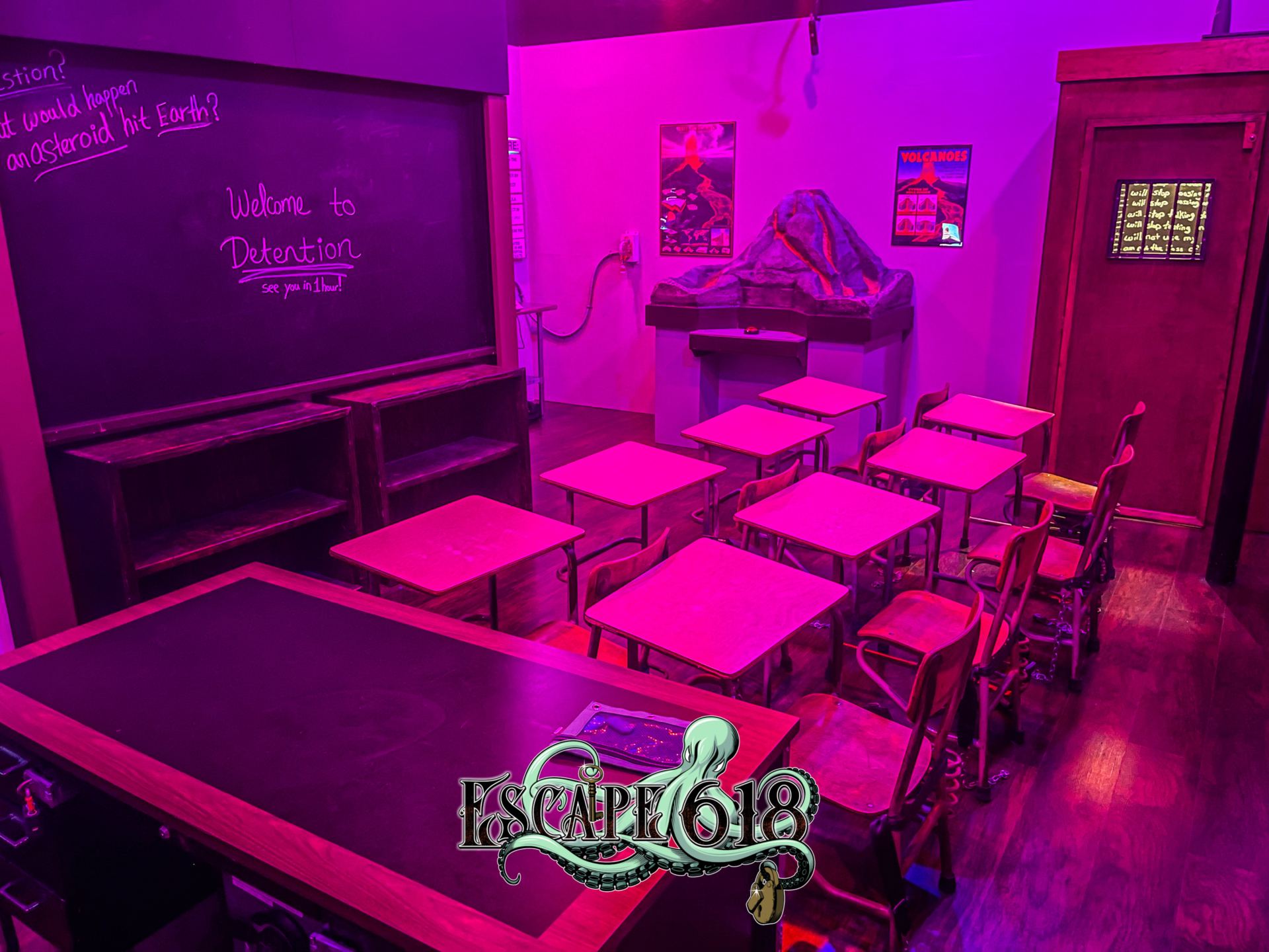 Detention escape room classroom with student desks and a "Welcome to Detention" chalkboard