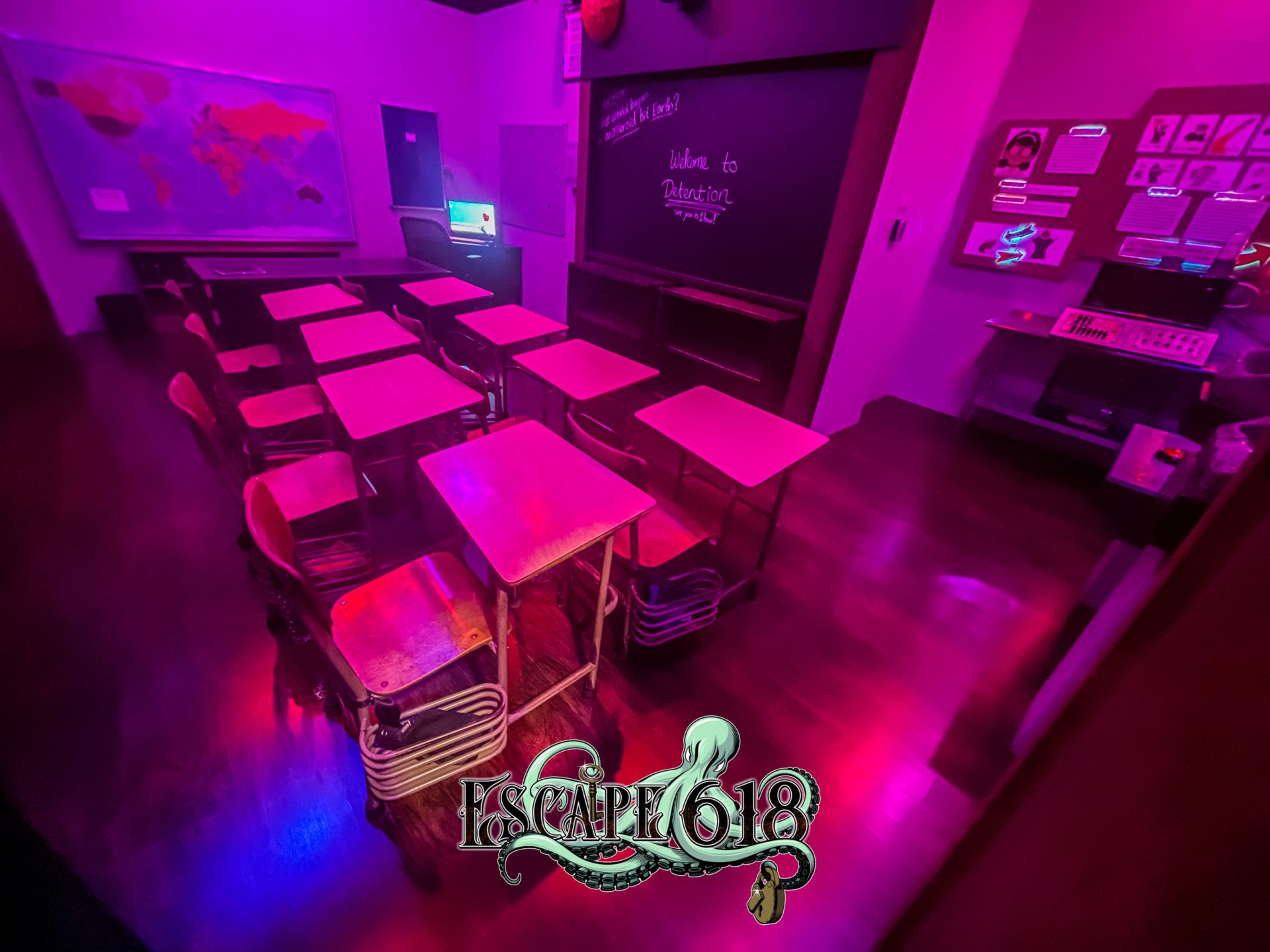 Rows of student desks and chalkboard in the Detention escape room at Escape 618