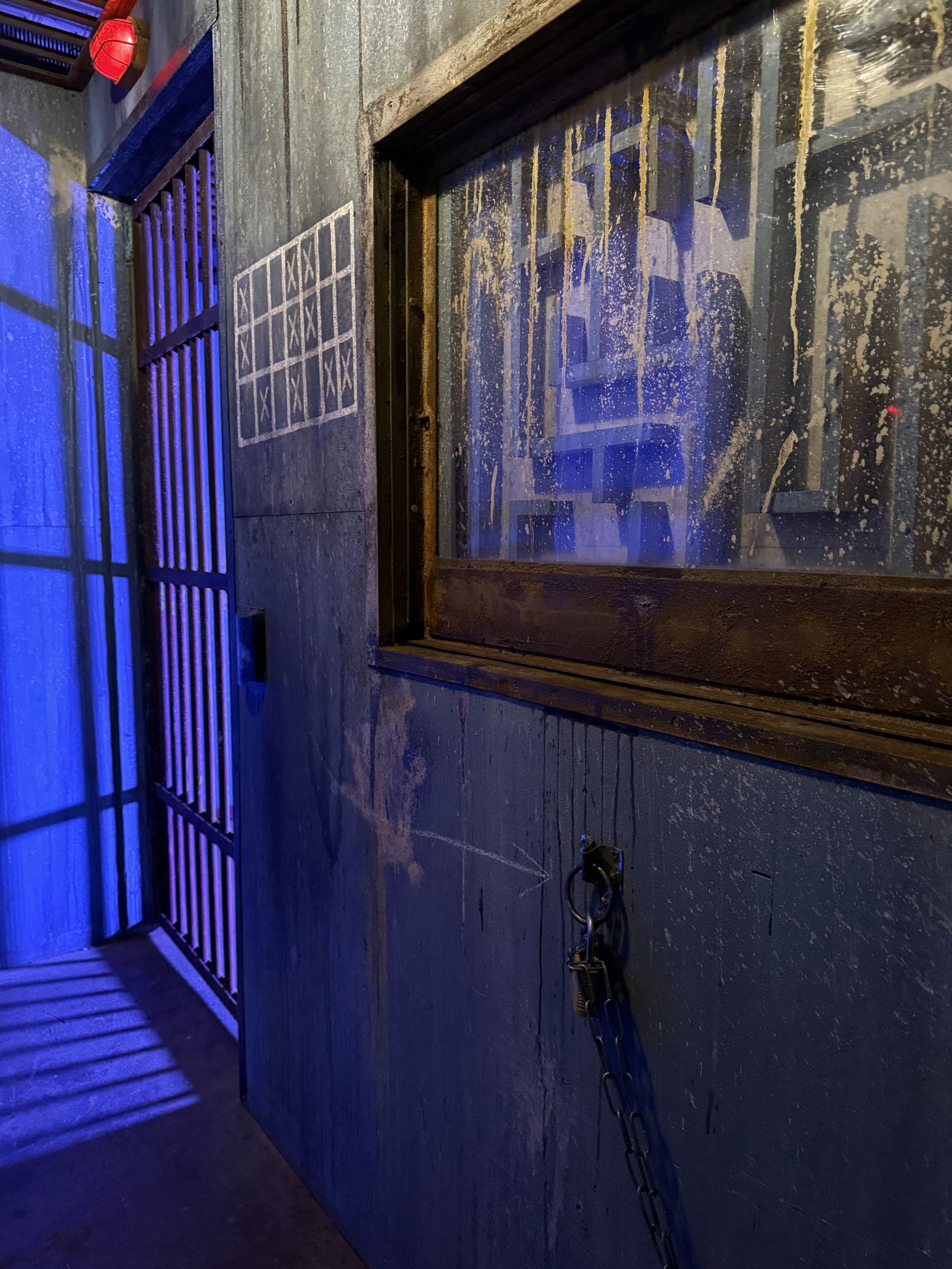 Barred cell and weathered prison wall inside The Jail Cell escape room in Belleville, IL